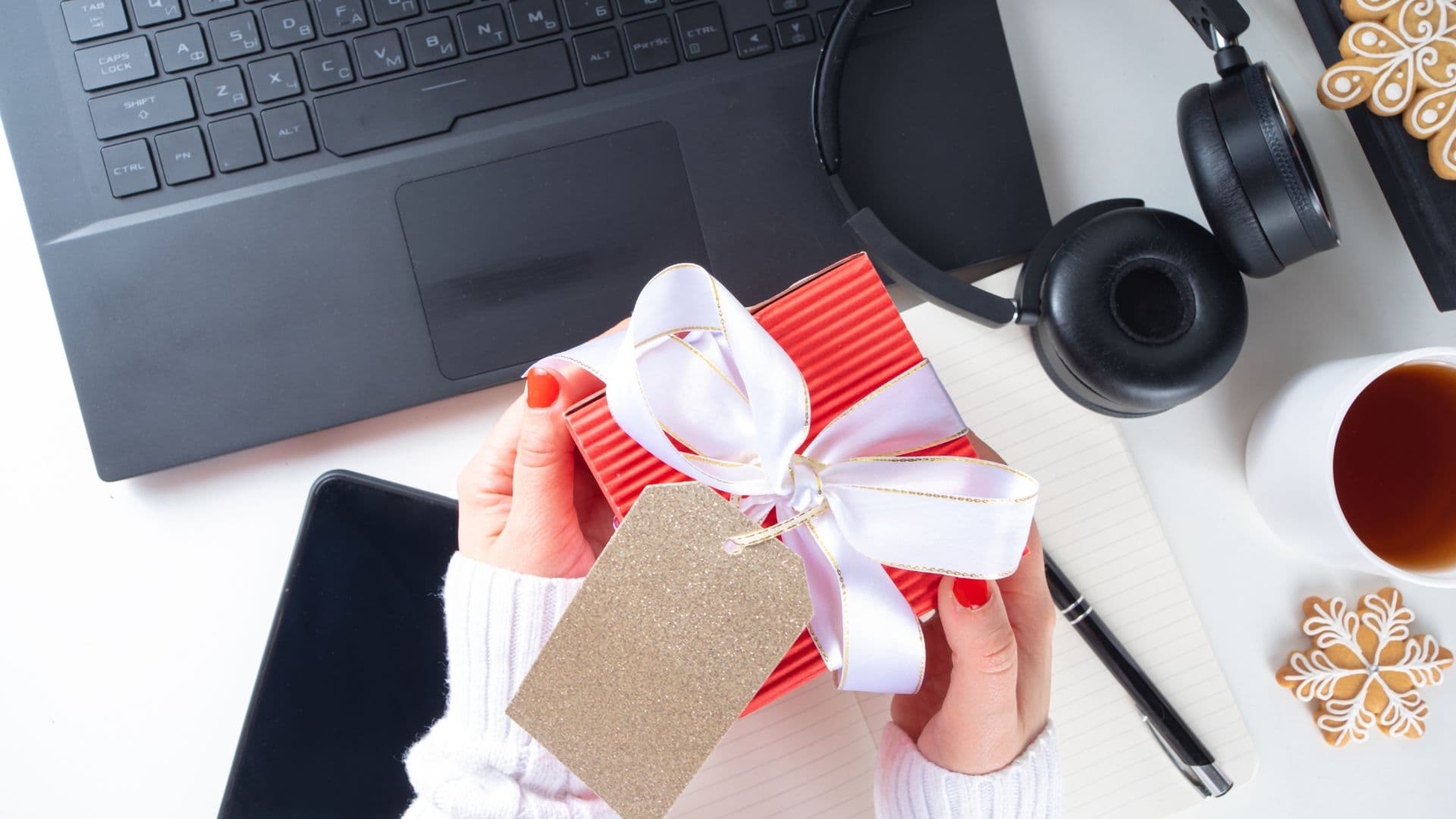 Cleaning service admin opening gift from employee at desk