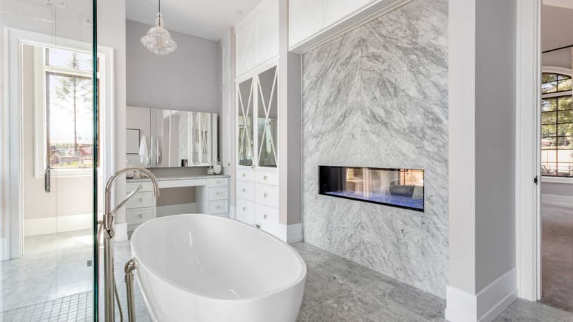 Marble walled bathroom with white tub in the middle